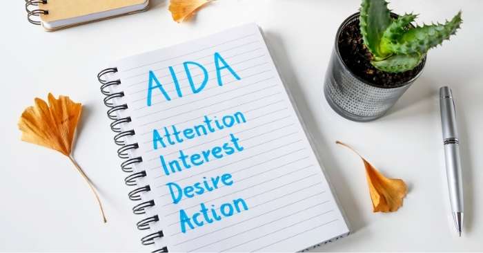 imagem de um caderno com a estratégia aida escrita: atenção, interesse, desejo e ação