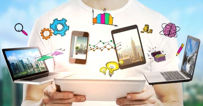 Homem segurando um tablet, com ícones de celulares, notebooks, engrenagens, cérebro, lâmpada e gráficos sendo projetados da tela, representando ideias de empreendedorismo digital